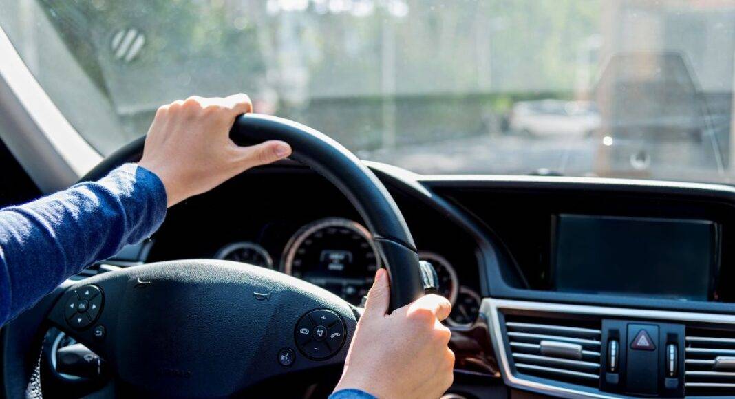 Condutor ao volante de um automóvel numa estrada