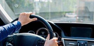 Condutor ao volante de um automóvel numa estrada